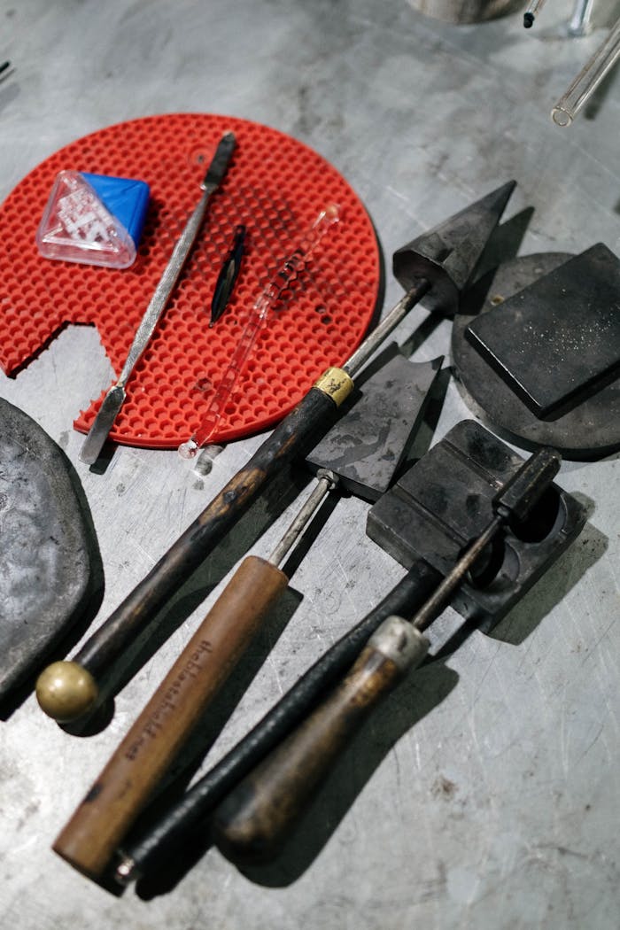 Close-up of various hand tools on a metal workbench surface.