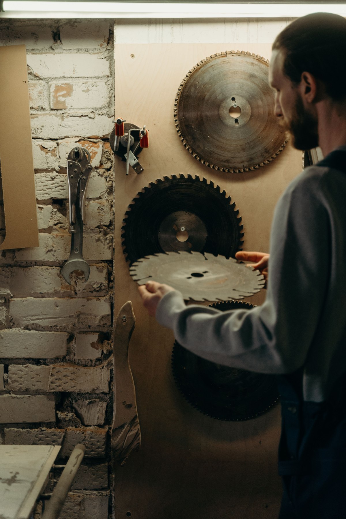 A woodworker organizing saw blades in a workshop
